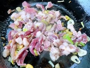锅中倒入底油加热放入葱姜蒜爆香放入鲜猪肉炒至变色