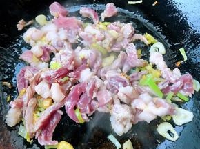 锅中倒入底油加热放入葱姜蒜爆香放入鲜猪肉炒至变色