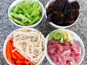 金针菇、芹菜、木耳焯好水，鲜猪肉和胡萝卜切丝，葱姜蒜切好备用