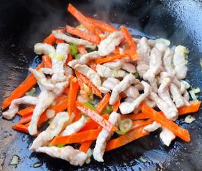 鲜猪肉丝炒至变色放入胡萝卜炒至断生