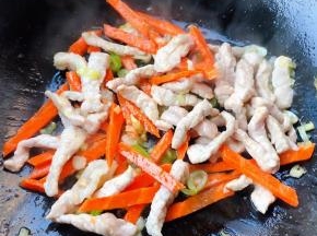 鲜猪肉丝炒至变色放入胡萝卜炒至断生
