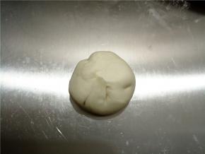 舀一勺（调料勺）糖在面皮中间，然后象包包子一样包好，不需要好看的褶子，包好就行，封口要捏紧，注意尽量不要有空气。封口没有捏紧的话，后面擀平时会开口，烤的时候就鼓不起来。