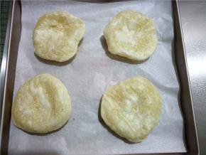 将烤盘取出，一一翻面，如果翻面时饼瘪了下去，只要没破就没有关系，再送回烤箱会再次鼓起，再次烤到鼓起表面微焦就好了。