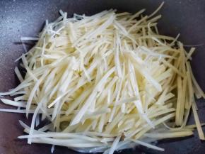 转大火放入土豆丝翻炒至透明。