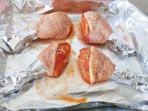 6.用锡纸把鸡腿尾部包起来，防止烤焦，刷酱料撒芝麻