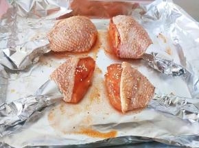 6.用锡纸把鸡腿尾部包起来，防止烤焦，刷酱料撒芝麻