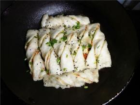 焖到水剩一点时，可以再撒一点葱花黑芝麻，盖上焖一分钟，再开盖煎到水收干，听到滋啦声，轻轻晃一下锅，小卷子可以移动就可以了。