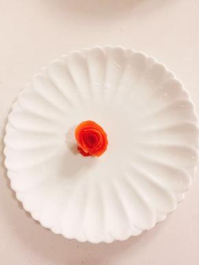 番茄皮卷成一朵花的形状，用牙签固定放在盘子中间！