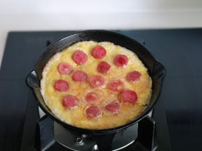 再摆放上煎熟的香肠，小火煎至蛋液凝固即可关火。