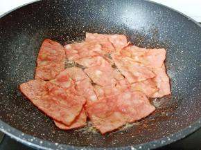 待培根煎到两面微黄。