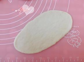 取一个松弛好的面团，擀开，拍掉边上的气泡。