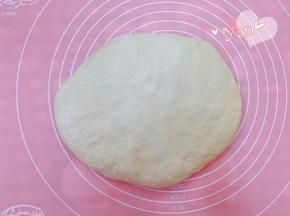 发酵好的面团放案板上轻拍排气，盖上保鲜膜，松弛20分钟。