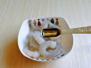 首先腌制虾仁，放入器具中，加入料酒去腥。