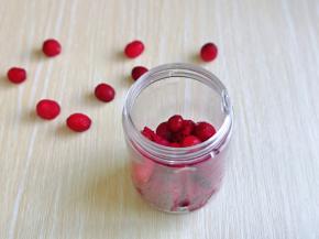 把切好的火龙果和蔓越莓放入果汁杯中。