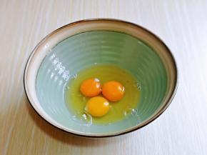 首先将鸡蛋磕入大口器具中。