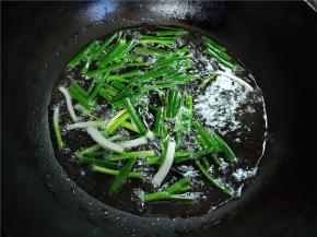 锅里倒入适量玉米油，我是倒了半碗油。先下葱白炸几分钟，再下葱叶。油要没有什么味道的油，不然会掩盖小葱的香味。要小火。