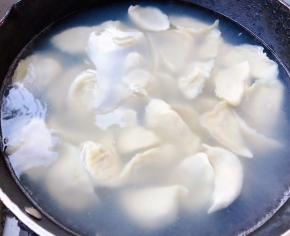 锅中倒入适量清水煮沸放一点点盐这样饺子不易粘连再依次放入饺子轻轻的搅拌一下防止粘锅底大火煮起来