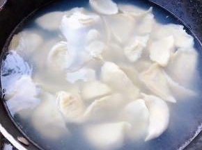 锅中倒入适量清水煮沸放一点点盐这样饺子不易粘连再依次放入饺子轻轻的搅拌一下防止粘锅底大火煮起来