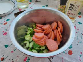 把切好的黄瓜跟香肠一并倒入小盆内。