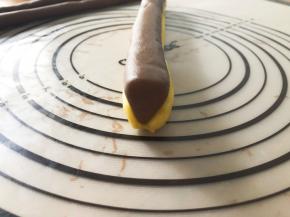  大的可可面团搓成三角形状，下面用原味面团包裹起来，这样才能放平做耳朵