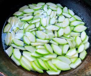 西葫芦一切为二片去中间瓜瓤再一切为二切片放入开水中焯水断生