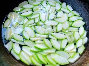 西葫芦一切为二片去中间瓜瓤再一切为二切片放入开水中焯水断生