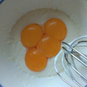 把准备好的蛋黄倒入面糊中，“Z”字翻拌均匀。预热烤箱180度