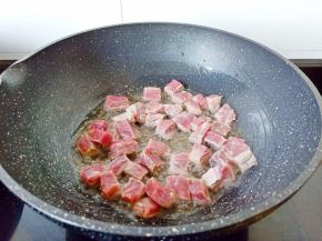炒锅置油烧至3层热，把牛肉粒炒香。