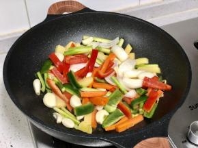 将青红椒段和蒜头倒入翻炒，加一些盐和鸡精，鸡精可以提鲜，不加也没关系。