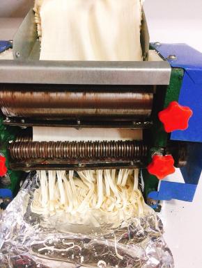 把电动压面机的面条刀安上，调到自己喜欢的厚度，再次启动压面机电源，压成面条！