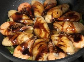 开盖后将调好的酱汁均匀倒在鸡翅和虾的表面，继续盖上锅盖焖五分钟，酱汁浓郁，满屋飘香；