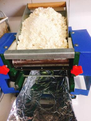 醒好的面絮放入电动压面机中，启动电动压面机，压成面片！（第一道面片可能不是特别完整，没事的，反复多压几次就好了！）