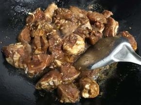 6.倒入腌制好的鸡块翻炒均匀