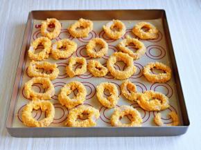 烤盘中垫上油纸，将鱿鱼圈依次摆放在烤盘中，并间隔距离。