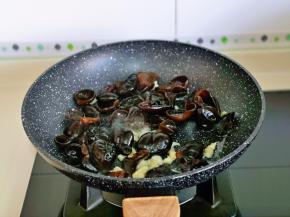 锅中加入食用油加热，加入切好的大蒜炒香，再加入黑木耳。