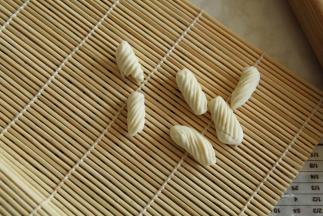 洗干净小手，擦干。大拇指按住面块，往右上方略用一点点力碾压过去就行。猫耳朵就自然卷曲好了，带花纹的哟！熟练的小伙伴可以左右手一起开工！