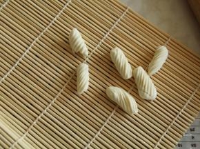 洗干净小手，擦干。大拇指按住面块，往右上方略用一点点力碾压过去就行。猫耳朵就自然卷曲好了，带花纹的哟！熟练的小伙伴可以左右手一起开工！