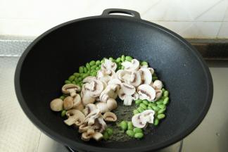 搓完猫耳朵，将小青菜清洗干净。白蘑菇去柄洗净后，切片。毛豆也清洗干净，沥干水分。干净无水不粘锅，倒入玉米油，开大火将油烧热，下姜片爆香，放入毛豆和白蘑菇片，一起翻炒1-2分钟。