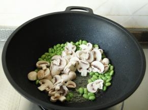搓完猫耳朵，将小青菜清洗干净。白蘑菇去柄洗净后，切片。毛豆也清洗干净，沥干水分。干净无水不粘锅，倒入玉米油，开大火将油烧热，下姜片爆香，放入毛豆和白蘑菇片，一起翻炒1-2分钟。