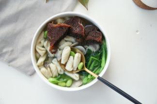 装入碗里，放上几片卤牛肉，热腾腾的青菜蘑菇猫耳朵就完成啦！主要家里有孩子啊，吃蔬菜面比较多，一来品种丰富一些！二来营养均衡嘛！煮面食的蔬菜可以替换成自己喜欢的呀，例如加点胡萝卜丝之类的！不喜欢豆类的可以不放！