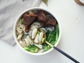 装入碗里，放上几片卤牛肉，热腾腾的青菜蘑菇猫耳朵就完成啦！主要家里有孩子啊，吃蔬菜面比较多，一来品种丰富一些！二来营养均衡嘛！煮面食的蔬菜可以替换成自己喜欢的呀，例如加点胡萝卜丝之类的！不喜欢豆类的可以不放！