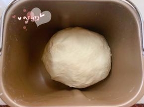 接着做吐司面团。除黄油外的所有材料，先液体后固体的顺序放入面包机桶内。揉面20分钟后再加入黄油揉15分钟。