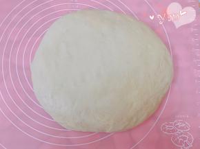 发酵好的面团放案板上轻拍排气。