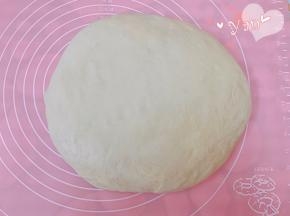 发酵好的面团放案板上轻拍排气。