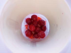 将草莓块和蔓越莓鲜果一起放入榨汁杯。