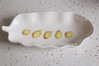 将姜片铺在蒸鱼盘的底部，可以预留两片，一些放在鱼肚子里，一些放面上，蒸鱼的时候，姜片不能少。