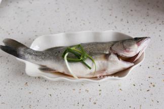 放上一个葱段，撒上少许盐，葱可以去腥，鱼的肚子里也要抹上料酒哦。