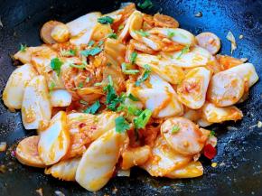 最后放入味精调味均匀使年糕均匀的裹上辣白菜汁撒上香菜葱花提鲜即可出锅