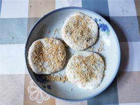 就用手掌将包好的团子按扁，然后两边粘上适量芝麻。