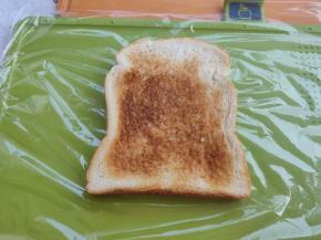 小菜板铺上保鲜膜，把烤好的吐司铺上。